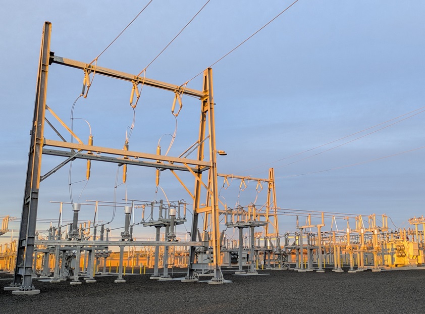 Golden hour on the 115 kV yard, energized and carrying load.